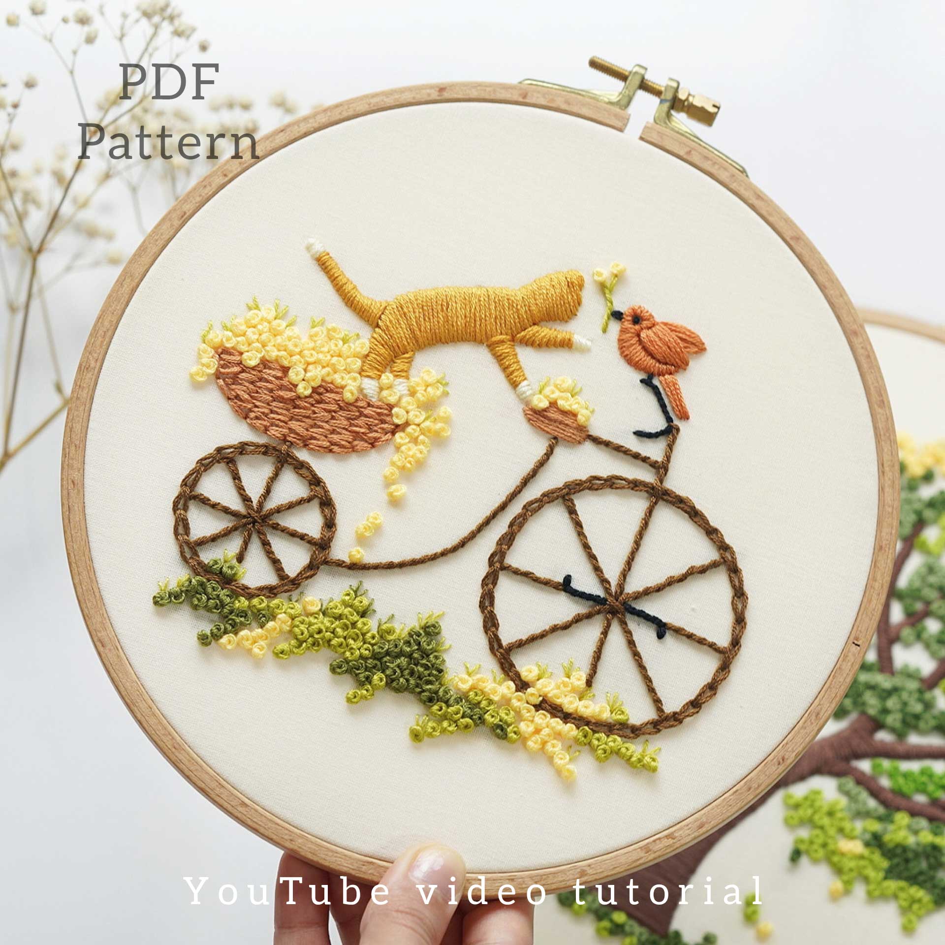 Embroidery of a cat riding a bicycle